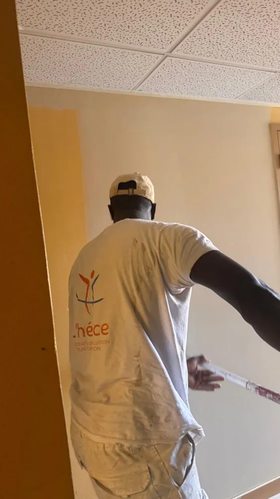 Salarié de L'Hélice en train de peindre un mur